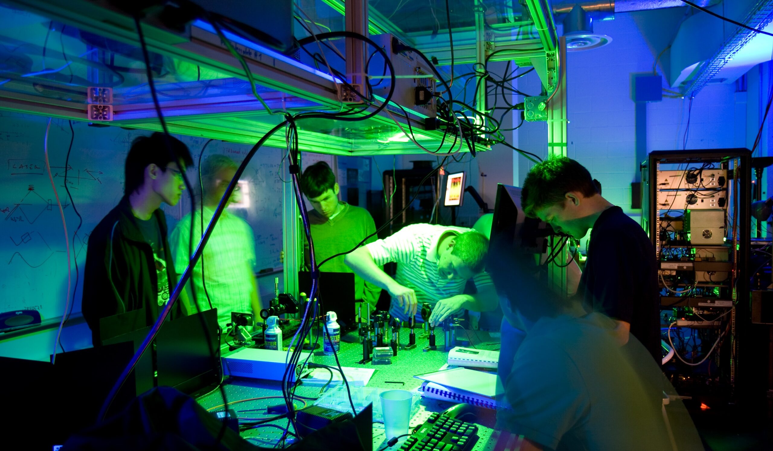 a group of people working in a dimly lit technology lab